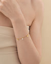 A delicate Coastal Shell and Pearl Bracelet in gold-plated sterling silver, featuring a fine chain with small shell and pearl charms, crafted with ethical sourcing and recycled metals.