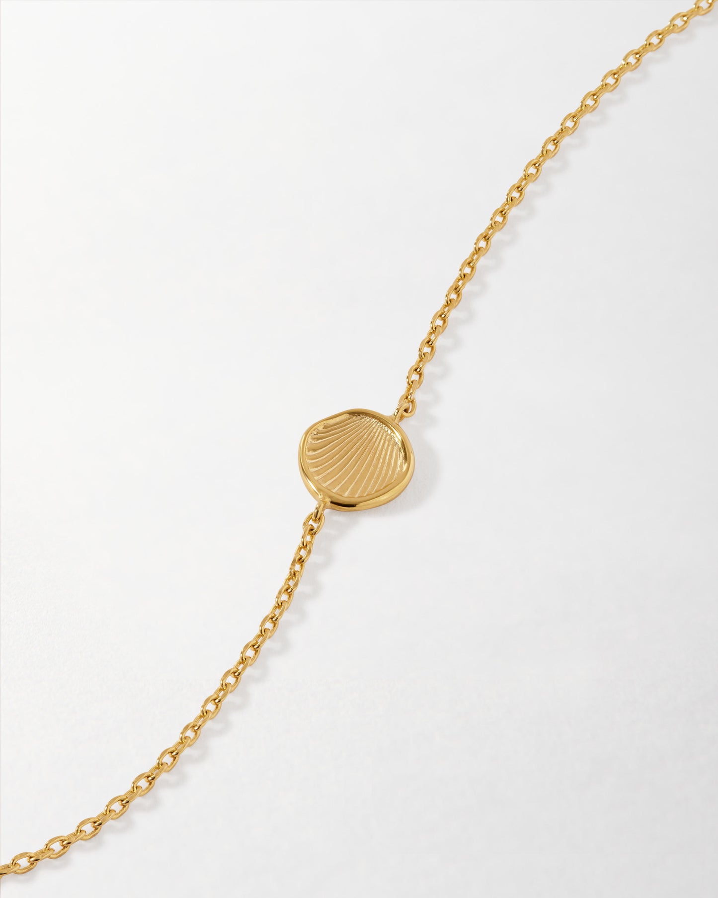 Coastal Shell Bracelet featuring a gold-plated chain with a delicate shell-shaped charm, crafted from recycled metals for considered jewellery that lasts.