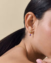 Close-up of a woman's ear wearing Pebble Amethyst February Birthstone Drop Earrings in gold-plated sterling silver, paired with a delicate gold chain necklace, highlighting considered jewellery crafted from recycled metals with ethical sourcing.