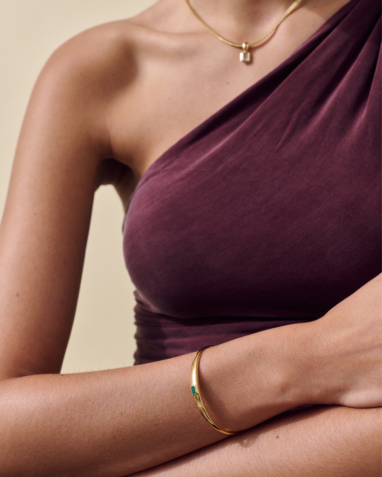 Woman wearing a Pebble Green Onyx Cuff crafted from gold-plated sterling silver, paired with a delicate gold necklace, showcasing ethical, considered jewellery made from recycled metals.