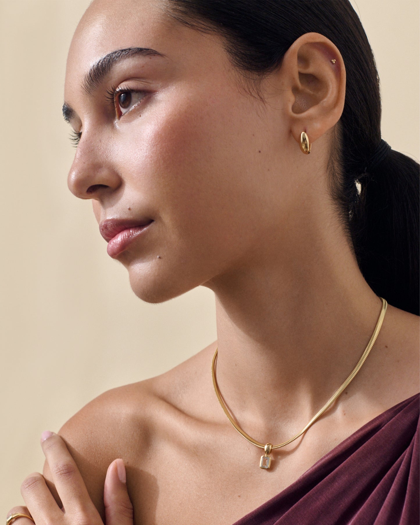 Close-up of a woman wearing the Pebble Hoop Earring - Gold, crafted in gold-plated sterling silver, showcasing considered jewellery with ethical sourcing and sustainable materials.
