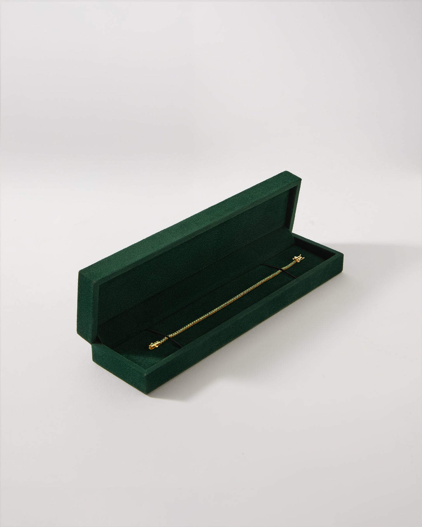 Solid Gold Lab-Grown Emerald Tennis Bracelet displayed in an elegant green velvet box, crafted in recycled metals with lab-grown diamonds for sustainable fine jewellery lovers.