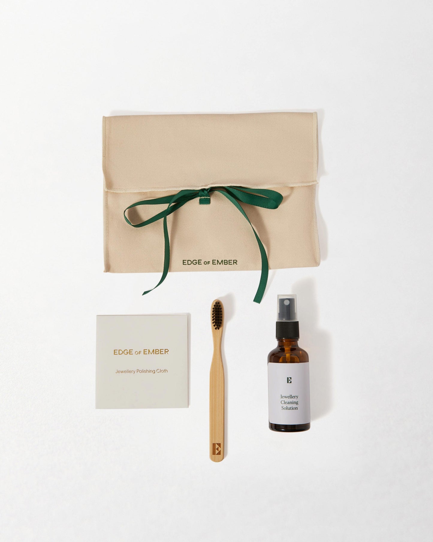 Jewellery Care Kit with eco-friendly pouch, bamboo brush, cleaning solution, and polishing cloth, designed for sustainable fine jewellery made from recycled metals.