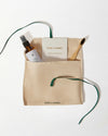 Jewellery Care Kit featuring a polishing cloth, cleaning spray, and bamboo brush neatly arranged in a beige pouch with green tie, crafted for solid gold and lab-grown diamond jewellery care.