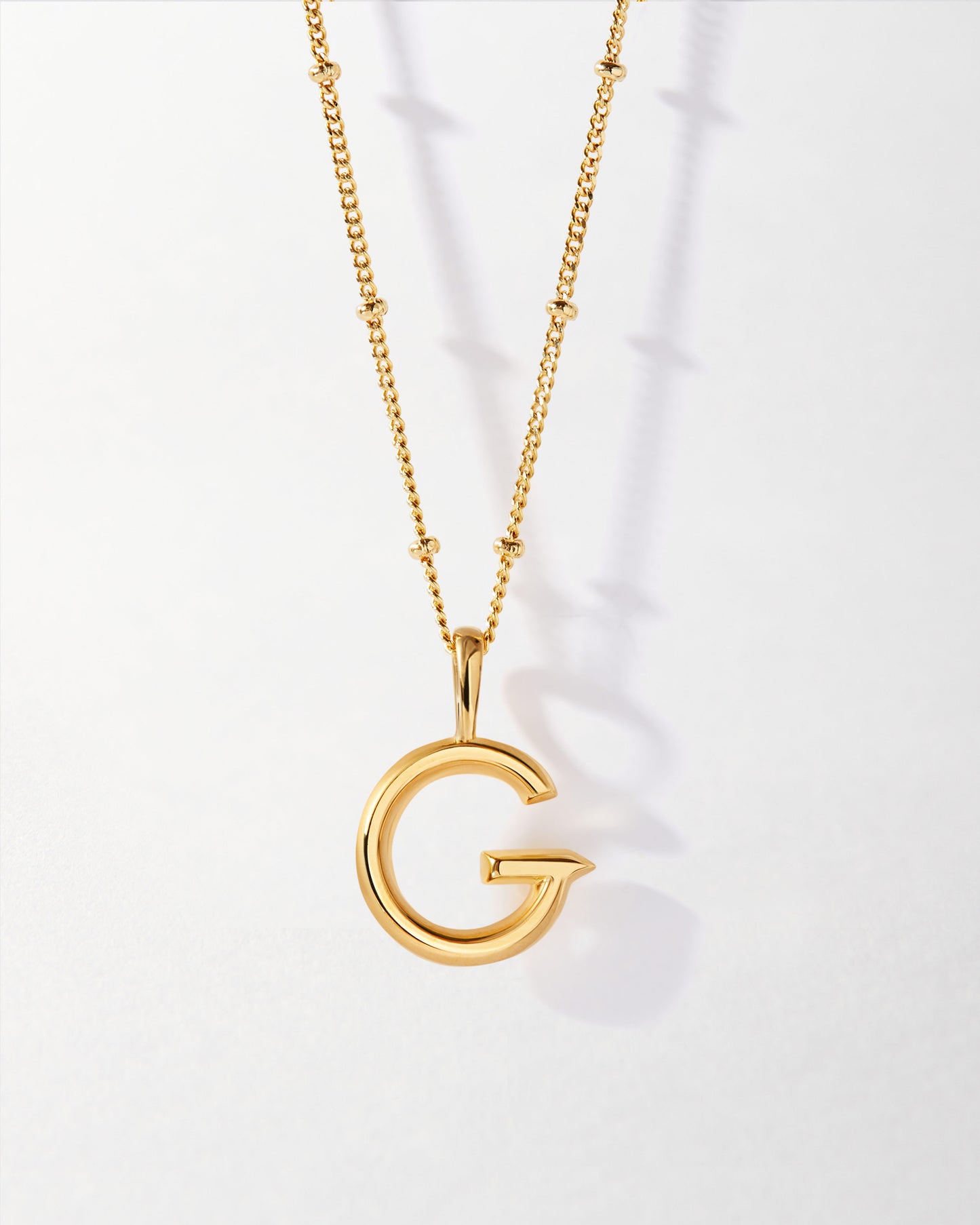 G' Initial Necklace - Gold featuring a polished gold-plated pendant in the shape of the letter G on a delicate chain, crafted with recycled metals for considered, fine jewellery.