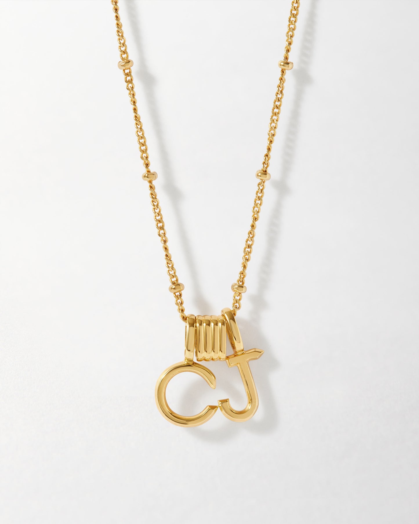 Mini 18ct Gold Necklace Spacer featuring gold-plated pendant letters on a delicate chain, crafted from recycled metals with ethical sourcing and built to last.