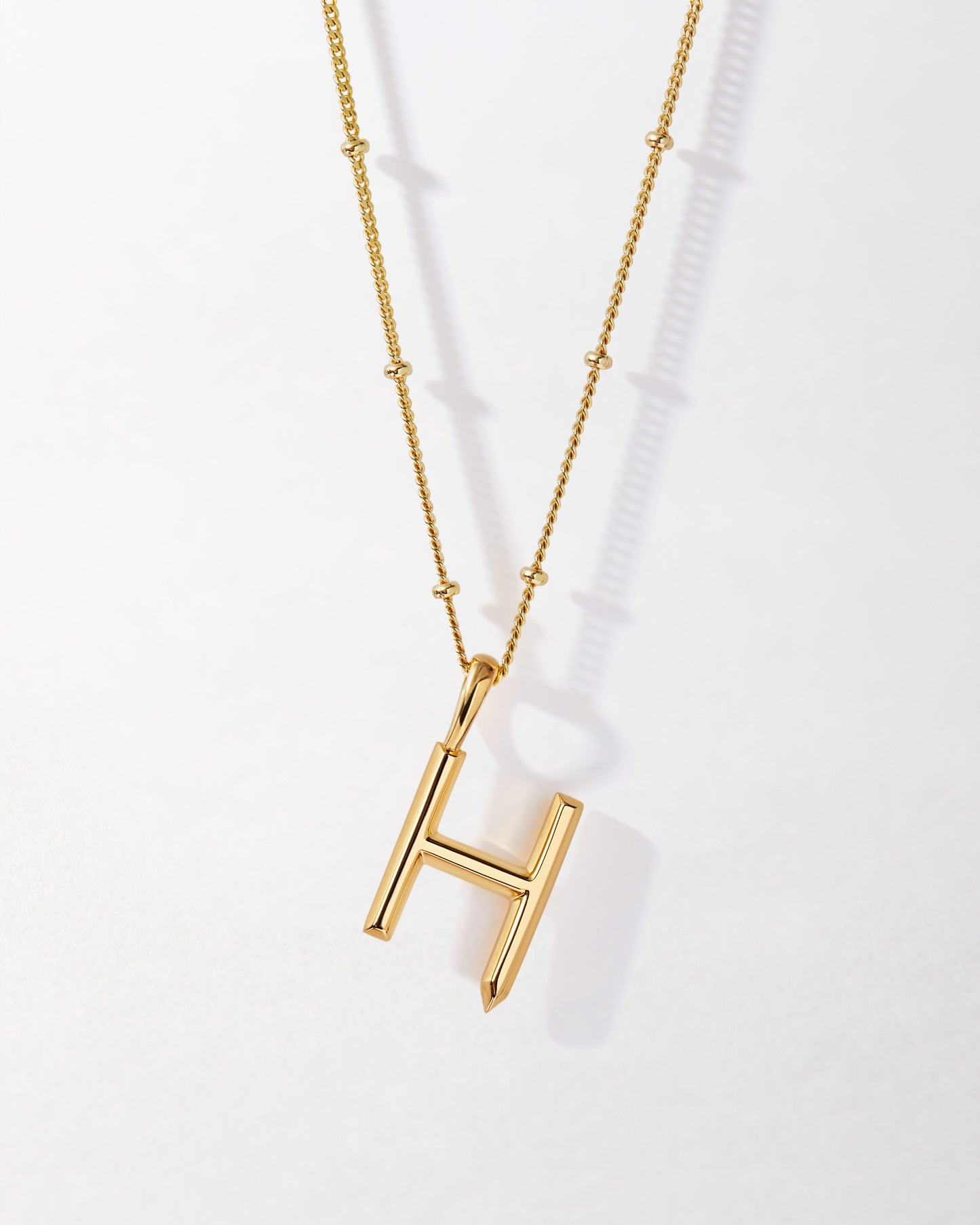 H' Initial Necklace - Gold featuring a sleek gold-plated pendant on a delicate chain, crafted from recycled metals for ethical, considered jewellery built to last.