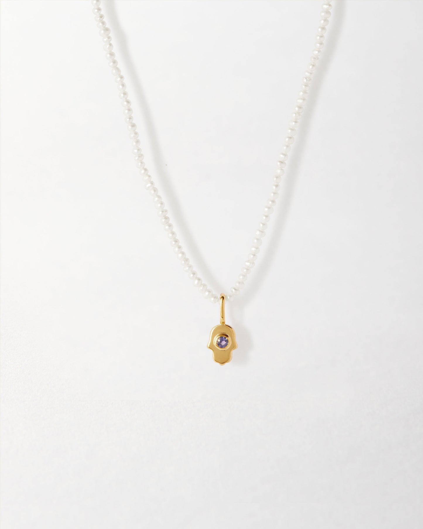 Mini Hamsa Pearl Necklace featuring a gold-plated pendant with a delicate pearl chain, crafted from recycled metals for ethical fine jewellery made to last.