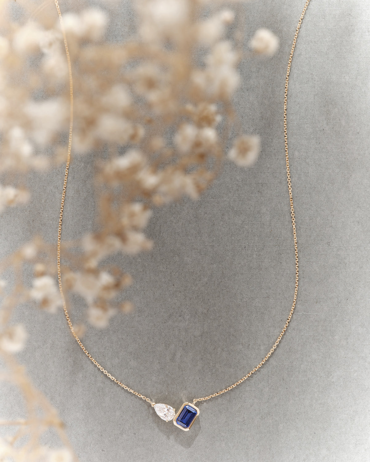 Toi Et Moi Blue Sapphire and Diamond Necklace featuring a gold chain and pendant with blue sapphire and diamond details in an elegant fine jewellery design