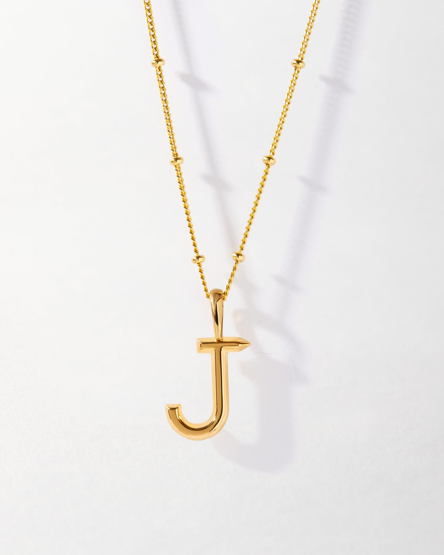 J' Initial Necklace - Gold featuring a polished gold-plated pendant letter J and delicate chain with small bead accents, crafted from recycled metals for considered jewellery made to last.