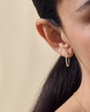 Close-up of a woman's ear wearing Large Diamond Halo Hoop Earrings crafted from solid 14ct gold with lab-grown diamonds, made from recycled metals for everyday fine jewellery.