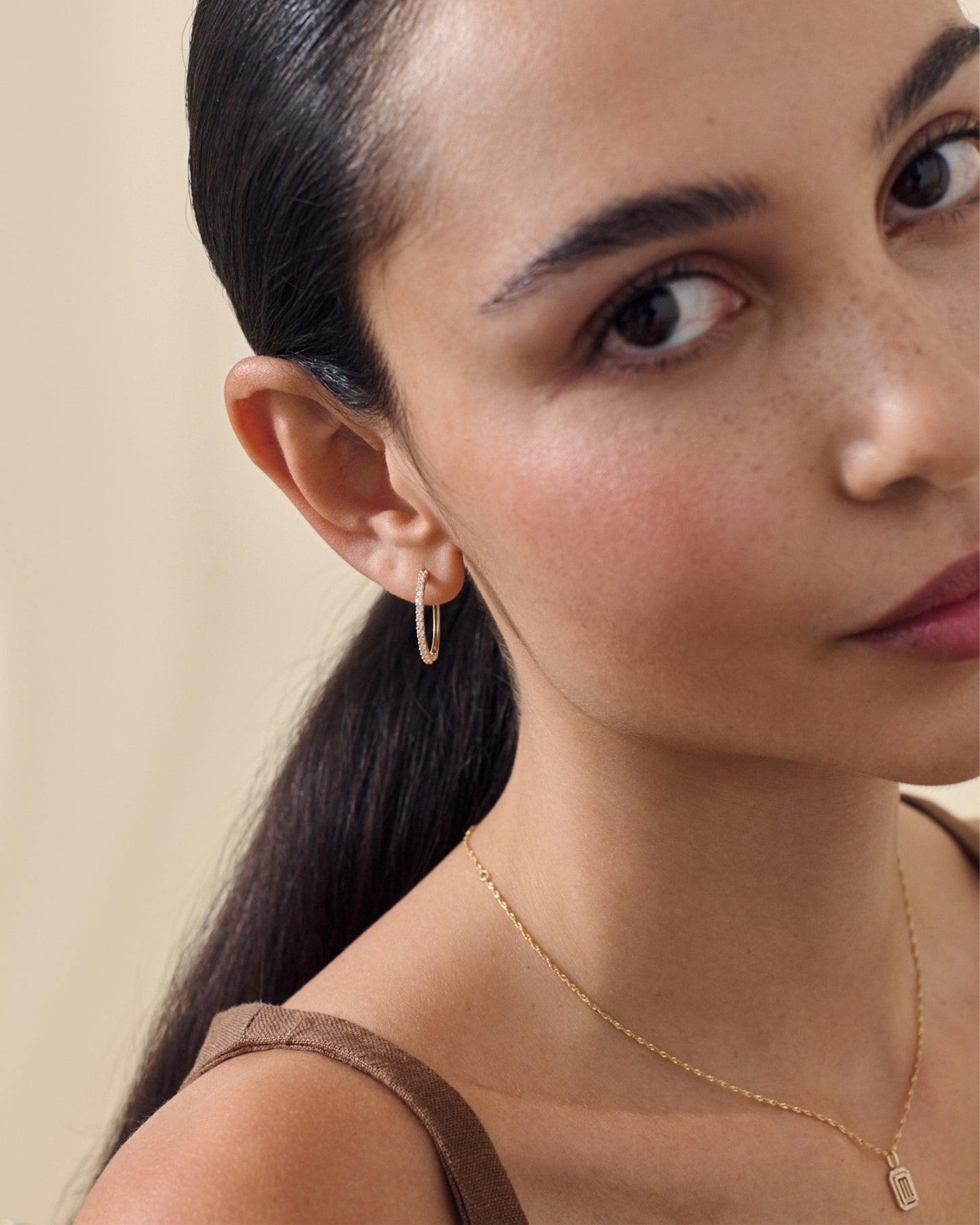 Close-up of a woman wearing Large Diamond Halo Hoop Earrings made from solid 14ct gold and lab-grown diamonds, showcasing ethical, recycled metals in fine jewellery designed for everyday wear.