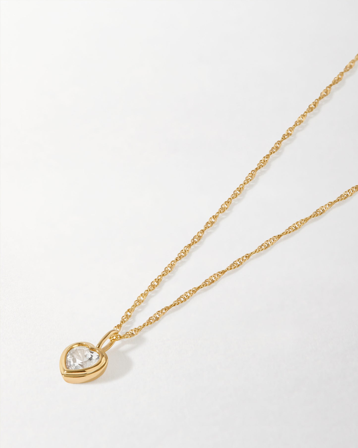 Solid Gold Large Heart White Sapphire Necklace featuring a delicate gold chain and a heart-shaped white sapphire pendant, crafted with recycled metals and ethical sourcing.