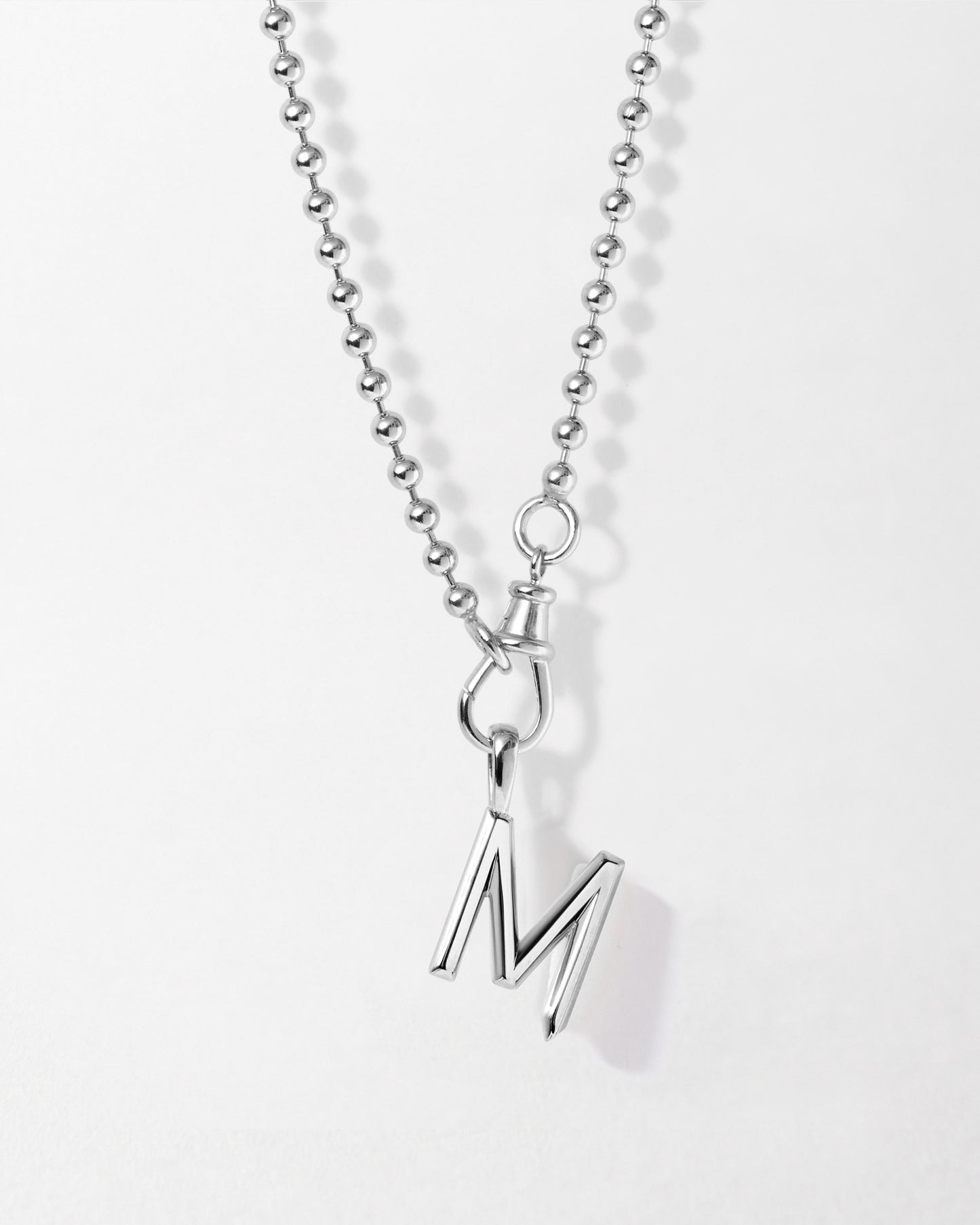 Initial Globe Necklace - Silver featuring a sleek sterling silver pendant in the shape of the letter M on a ball chain, crafted with recycled metals for fine everyday jewellery.