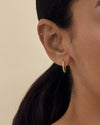 Close-up of a woman wearing Medium Diamond Halo Hoop Earrings crafted from solid 14ct gold with lab-grown diamonds, showcasing elegant, sustainable fine jewellery made from recycled metals.