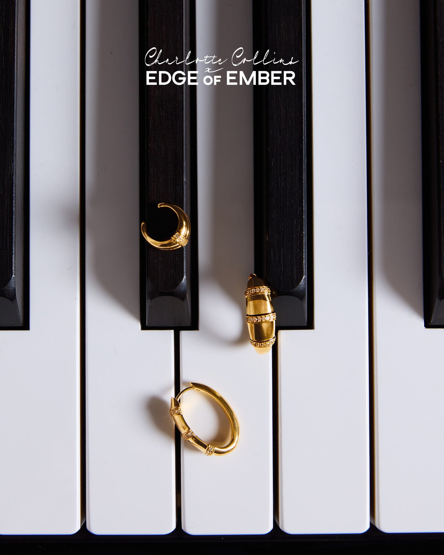 Charlotte Collins Dome Pavé Double Ear Cuff in gold-plated sterling silver displayed on piano keys, showcasing fine jewellery with elegant craftsmanship and sustainable luxury.