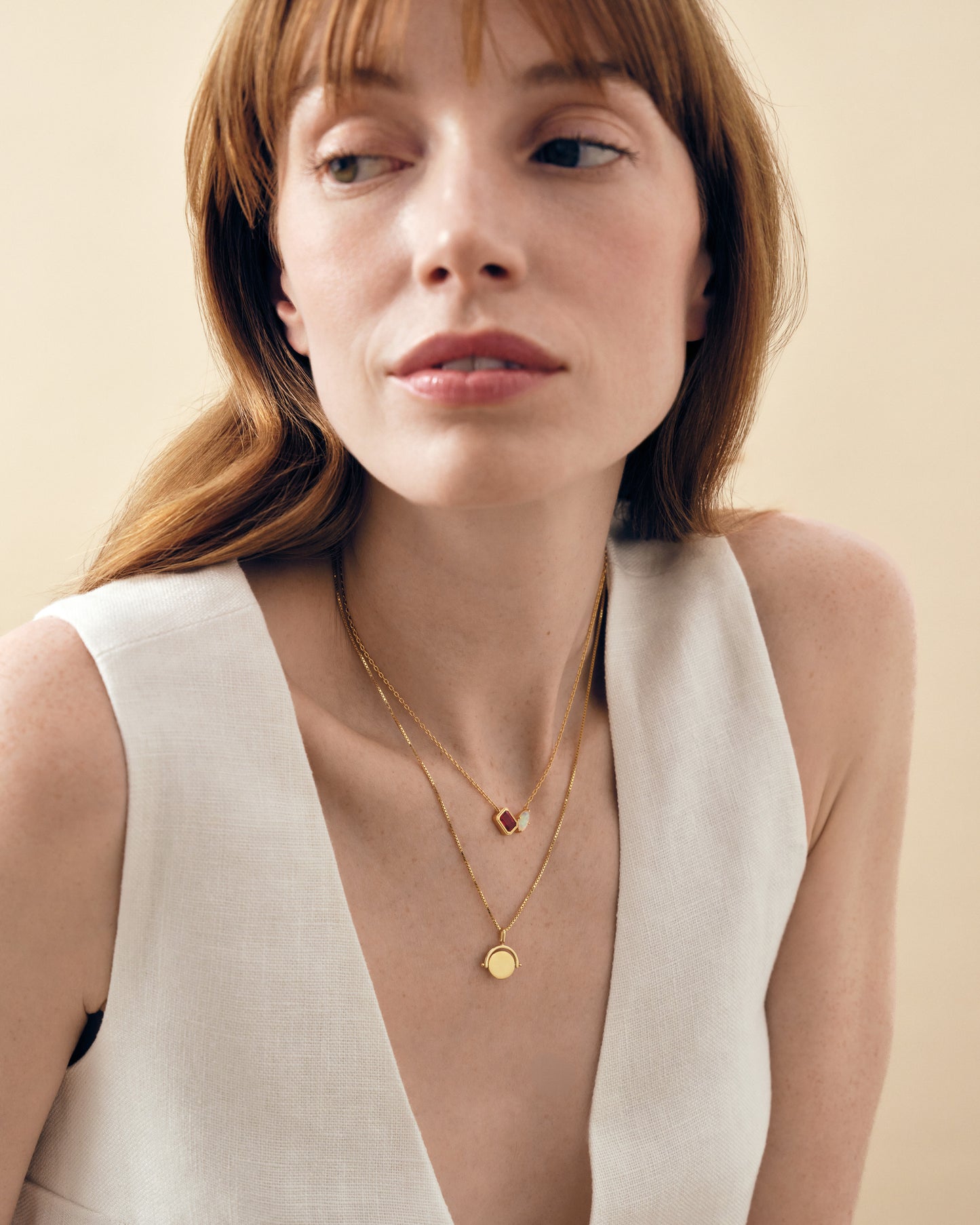 Woman wearing layered gold necklaces featuring a Mini Spinner Pendant made from gold-plated and sterling silver, showcasing considered jewellery built to last with ethical sourcing.