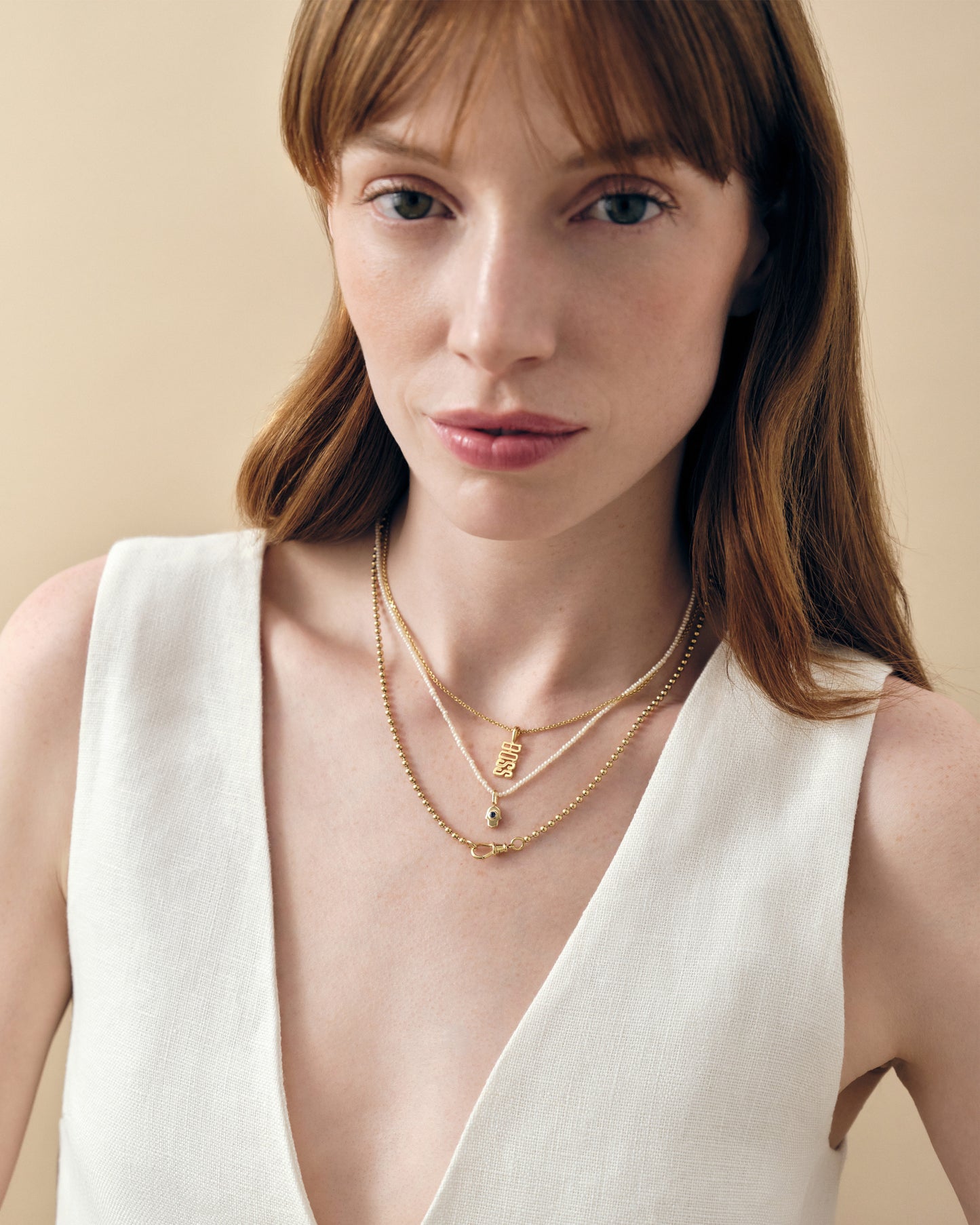 Close-up of a woman wearing the Mini Hamsa Pearl Necklace in gold-plated and sterling silver, showcasing fine sustainable jewellery crafted from recycled metals and designed for everyday elegance.
