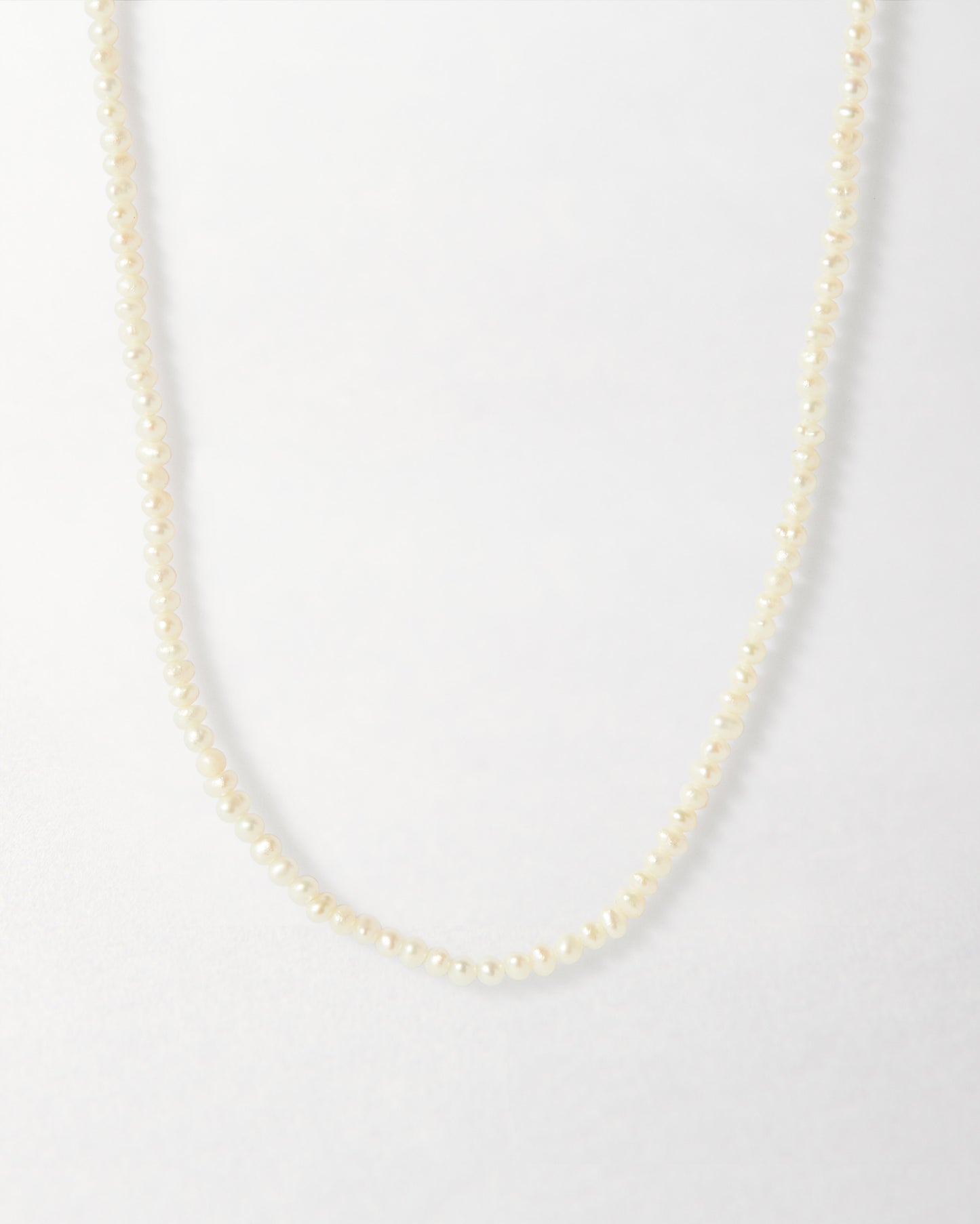 Mini Pearl Strand featuring delicate beaded pearls with a gold-plated finish, crafted in recycled metals for considered jewellery and everyday fine luxury.