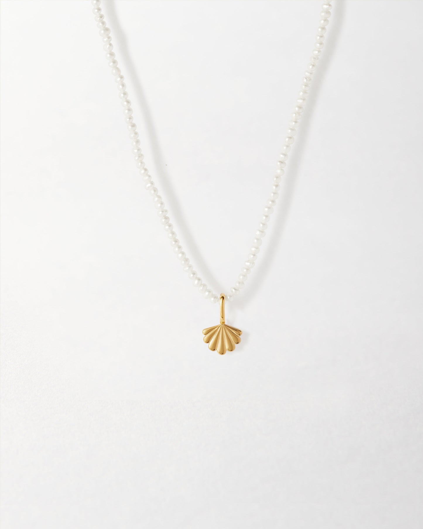Mini Shell Pearl Necklace featuring a delicate gold-plated shell pendant on a sterling silver pearl chain, showcasing considered jewellery made from recycled metals.