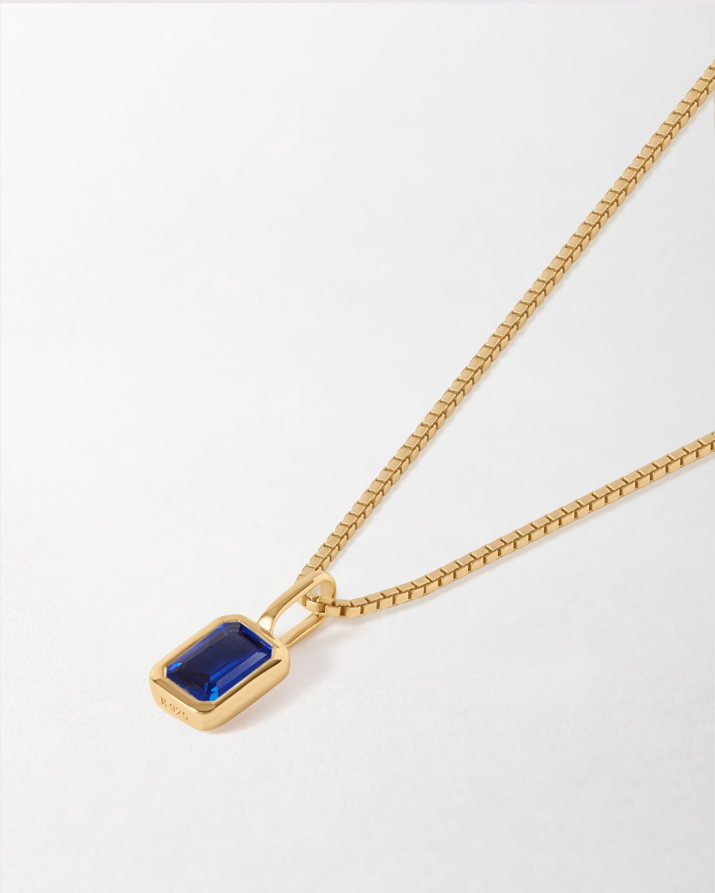Mini Deco Blue Sapphire September Birthstone Necklace featuring a gold-plated pendant with a deep blue sapphire on a delicate chain, crafted from recycled metals with ethical sourcing. Considered jewellery. Solid gold. Fine jewellery for the everyday. Made in recycled metals. Built to last.