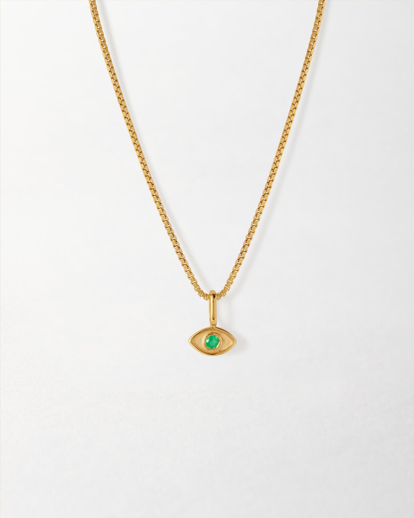 Mini Evil Eye Necklace featuring a gold-plated pendant with a green stone center on a delicate chain, crafted with recycled metals and ethical sourcing.