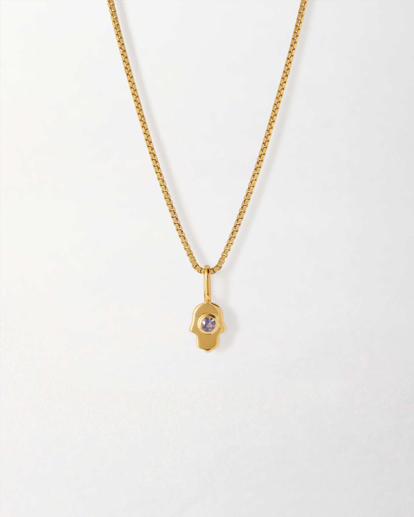 Mini Hamsa Necklace featuring a gold-plated pendant with a purple gemstone, crafted from recycled metals for considered, fine jewellery that lasts.