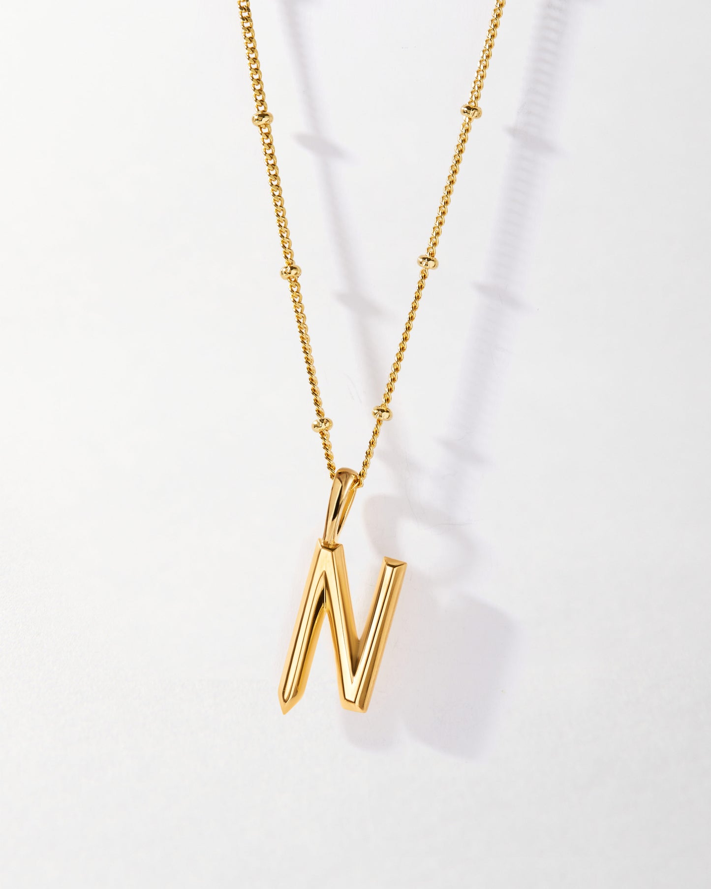 N' Initial Necklace - Gold featuring a delicate gold-plated chain with beaded accents and a polished letter N pendant, crafted with recycled metals and ethical sourcing for everyday fine jewellery.