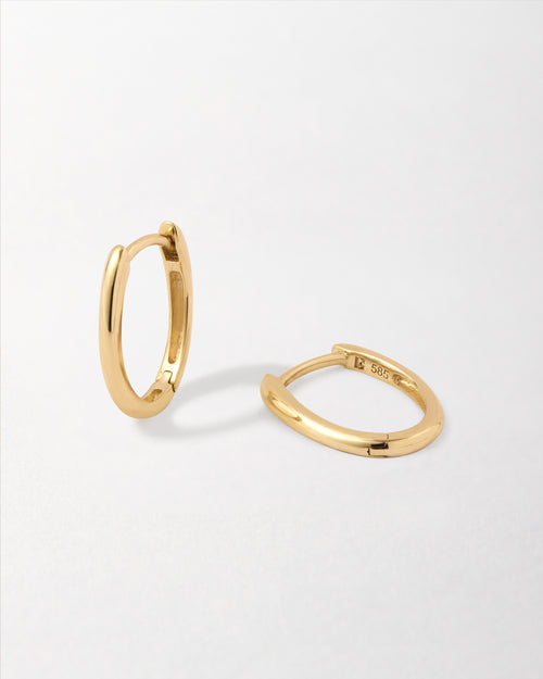Solid Gold Oval Hoop Earrings crafted from recycled solid 14ct gold, featuring a unique oval huggie design that combines considered jewellery with fine craftsmanship.
