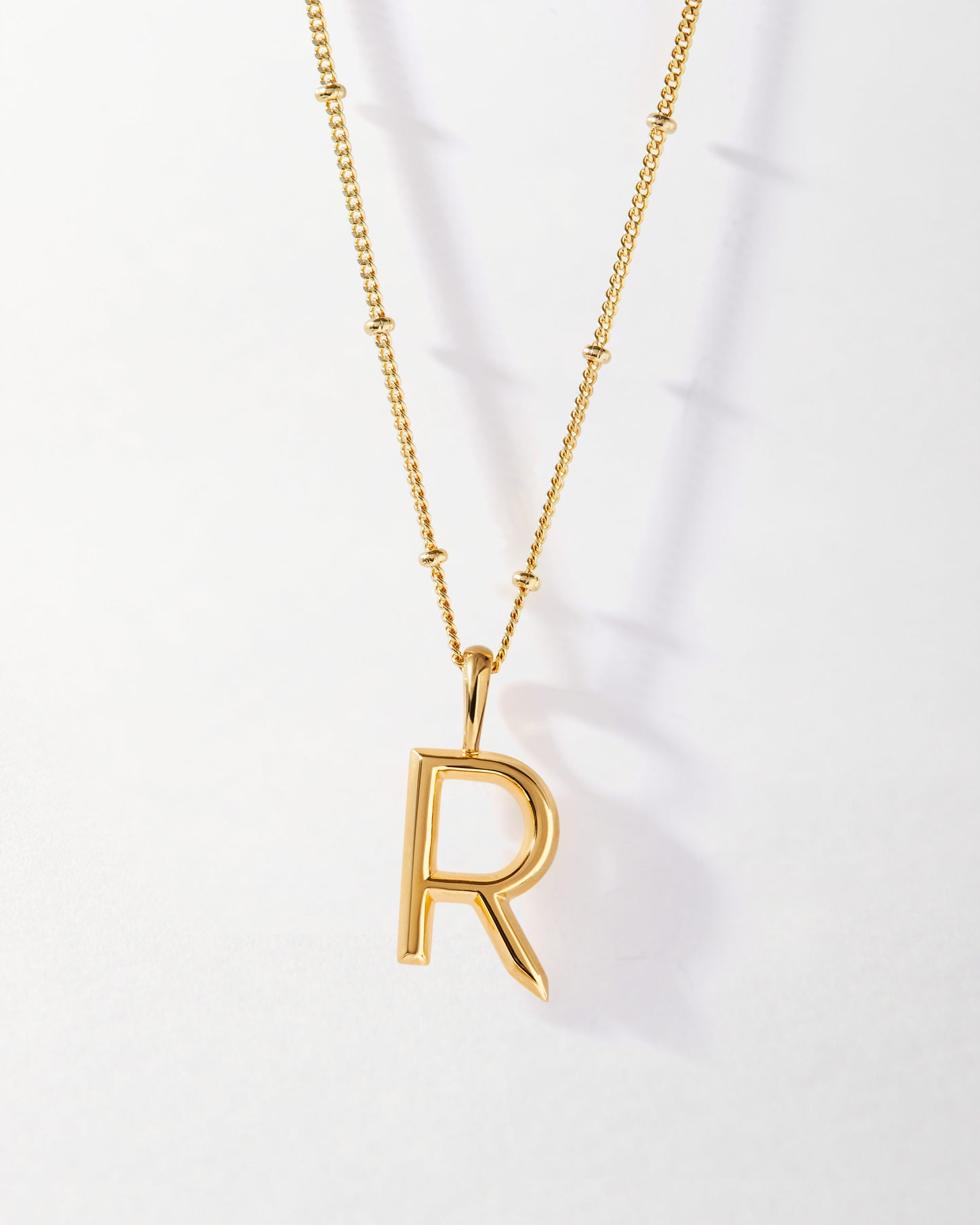 R' Initial Necklace - Gold featuring a sleek gold-plated pendant on a delicate chain, crafted with recycled metals for considered jewellery that lasts and shines every day.