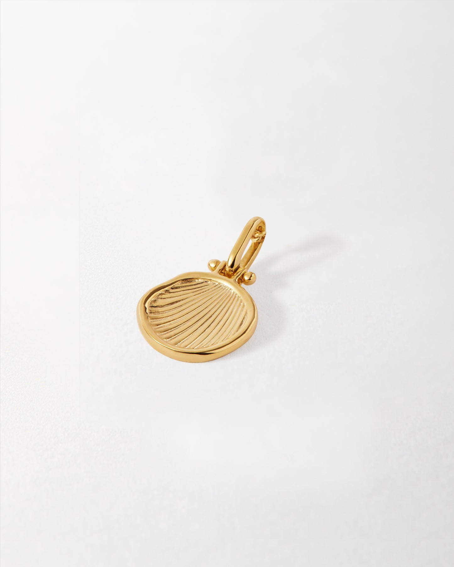 Close-up of a gold-plated Coastal Shell Pendant featuring detailed shell ridges, crafted as considered jewellery in recycled metals, built to last and perfect for everyday fine jewellery.