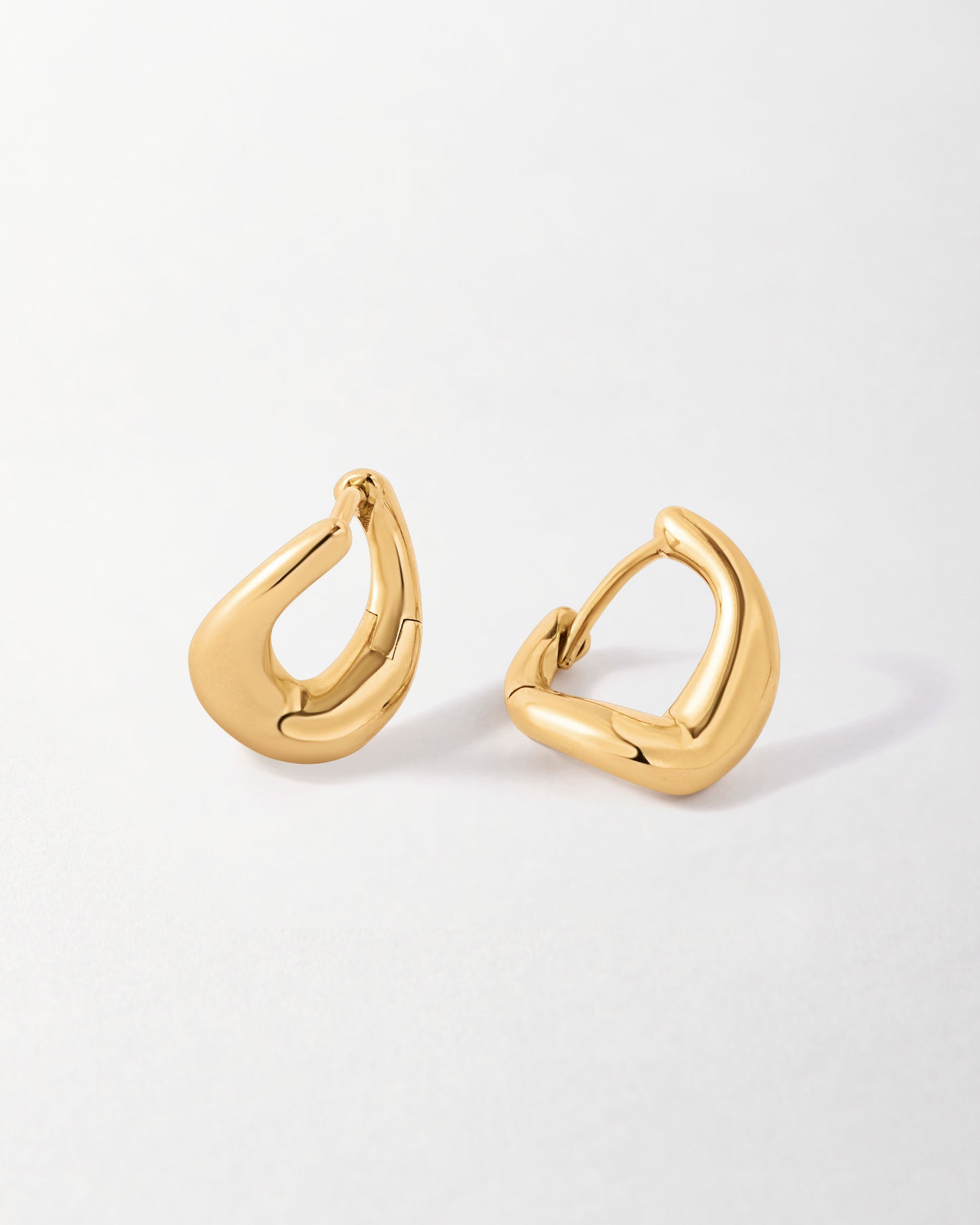Charlotte Collins Small Twist Hoop Earrings in polished gold-plated sterling silver, showcasing a modern twist on classic huggie and hoop styles, made with recycled metals.