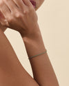 Close-up of a wrist wearing a Solid Gold Lab-Grown Emerald Tennis Bracelet featuring 14ct solid gold with lab-grown emeralds, crafted with recycled metals for everyday fine jewellery.