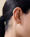 Close-up of a small stud earring in the upper ear piercing, showcasing the Solid Gold Heart Piercing Earring made from ethical recycled metals, designed for everyday fine jewellery.