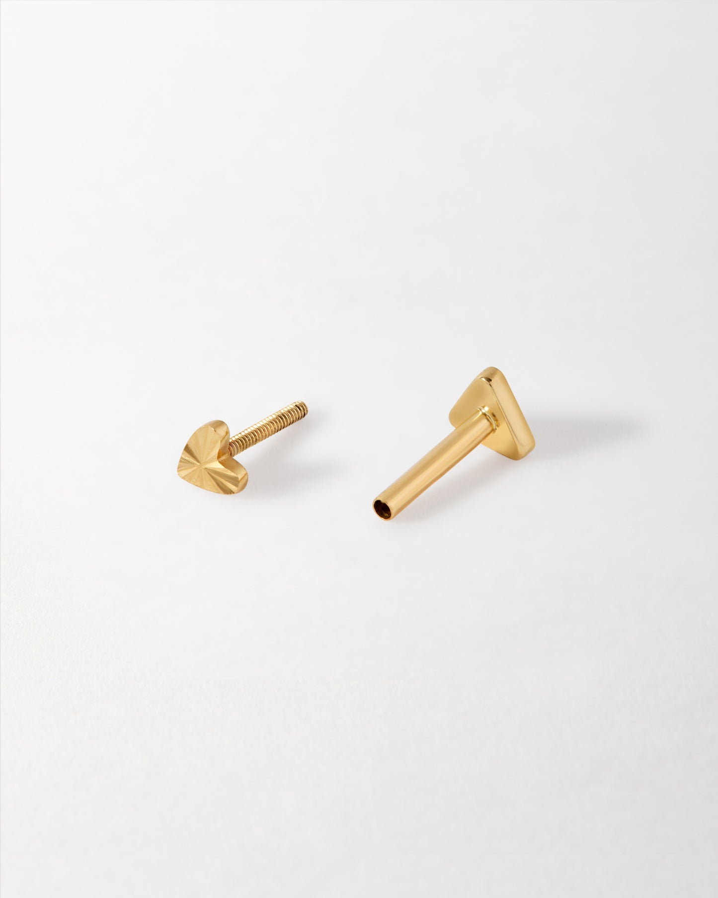 Solid Gold Heart Piercing Earring featuring a delicate solid gold stud heart and screw-back closure, crafted from recycled metals for ethical and sustainable fine jewellery.