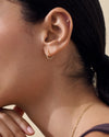 Close-up of a person wearing Solid Gold Huggie Hoop Earrings, showcasing fine craftsmanship in recycled 14ct solid gold, combining sustainable style with everyday luxury.