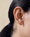 Close-up of an ear showcasing a Solid Gold Moon Piercing Earring made from ethically sourced recycled metals, perfect for everyday fine jewellery with a thoughtful design.