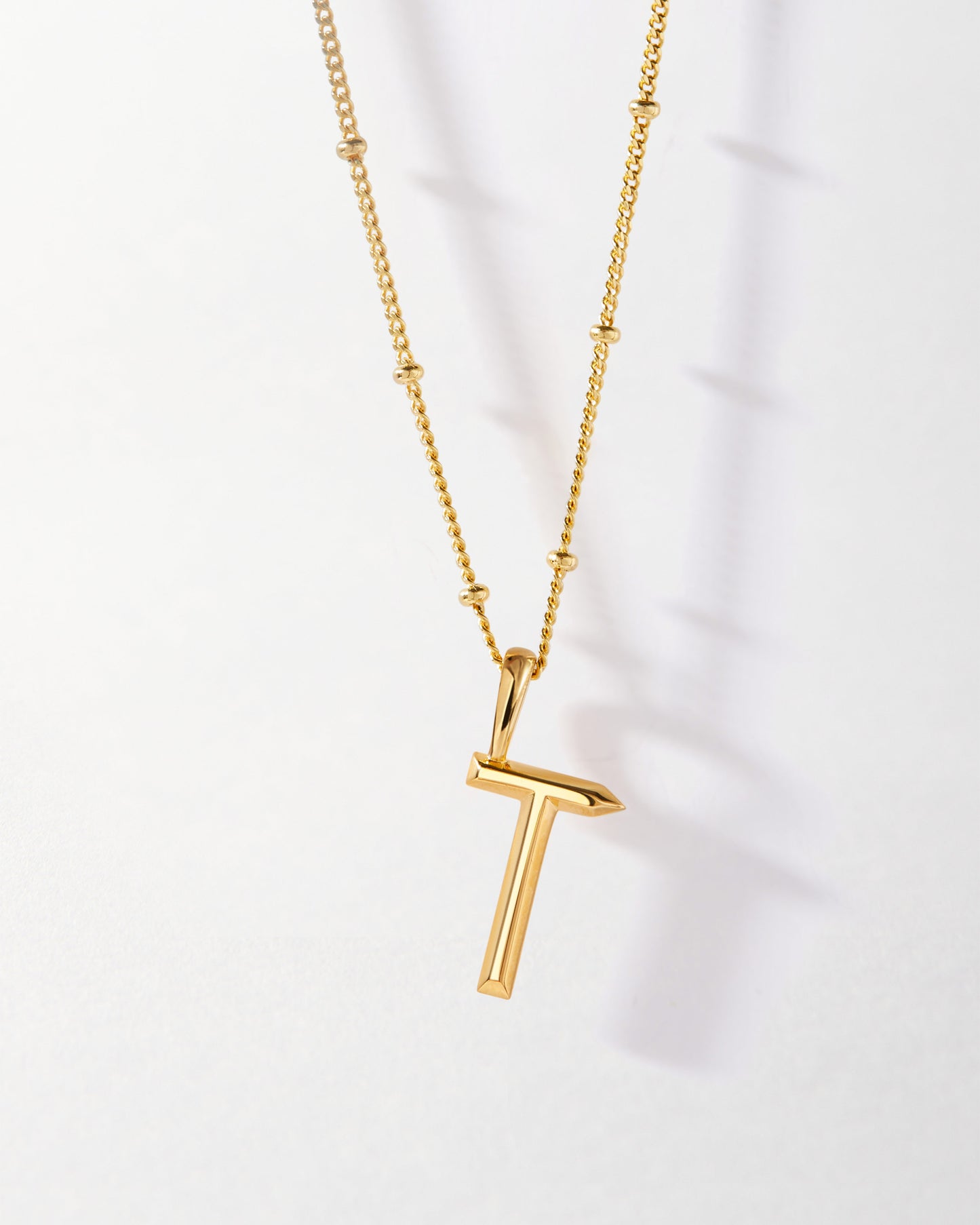 T' Initial Necklace - Gold featuring a sleek gold-plated pendant on a delicate chain, crafted from recycled metals with ethical sourcing for fine jewellery made to last.