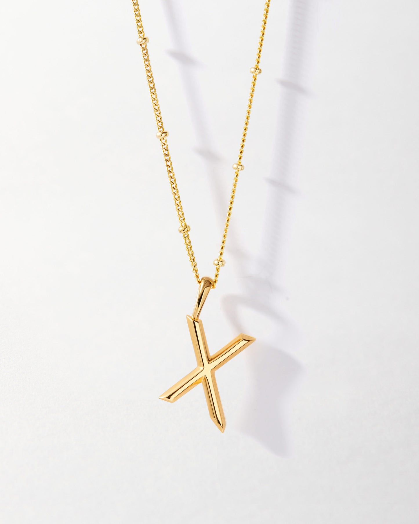 X' Initial Necklace - Gold featuring a sleek gold pendant on a delicate gold chain, crafted from recycled metals with ethical sourcing for everyday fine jewellery.