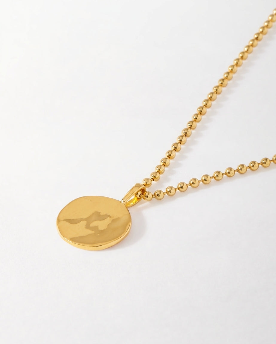 Coin Globe Necklace with a gold-plated globe pendant and beaded chain shown on a white background