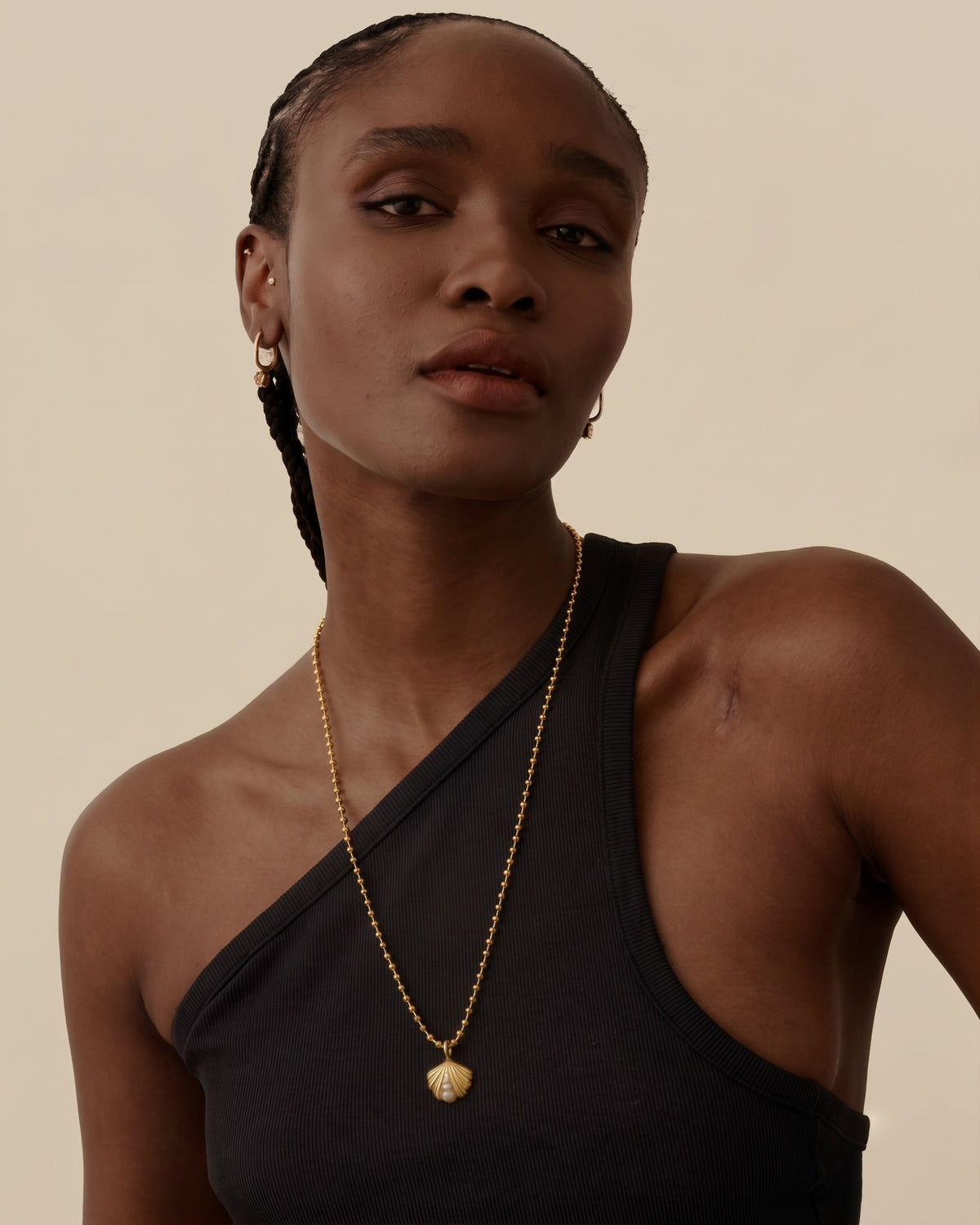 Ocean Shell Globe Necklace in gold plated sterling silver with a delicate chain and pendant worn by a model in a black top